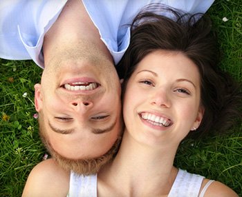 Man and woman showing off porcelain in veneers Orange California