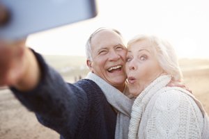 Man and woman smiling together after replacing missing teeth in Orange California