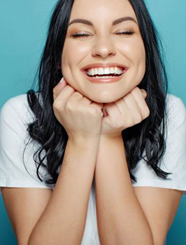 woman grinning after seeing her cosmetic dentist in Orange