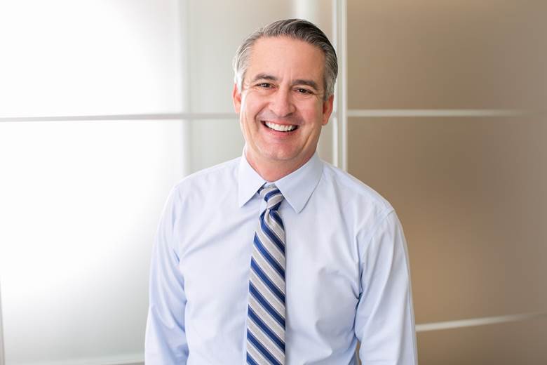 smiling man in business clothing standing in an office