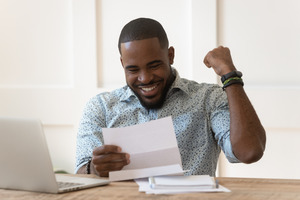 Excited man smiling and looking at a letter