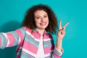Woman with front gap smiling and making a peace sign