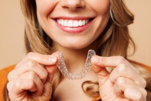 Woman smiling with her Invisalign tray