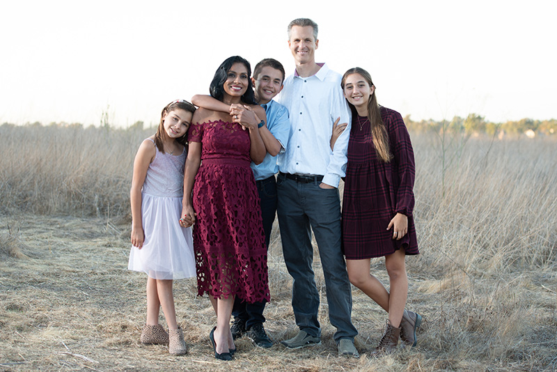 Doctor Michelsenher husband, and three children smiling for in a field.