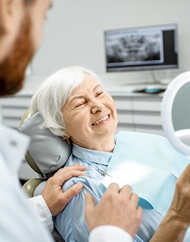 older woman smiling after getting dental implants in Orange