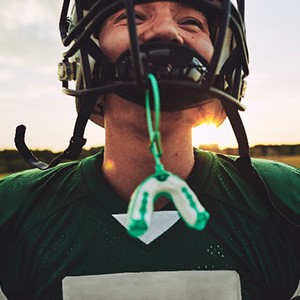 Closeup of mouthguard hanging from football player's helmet