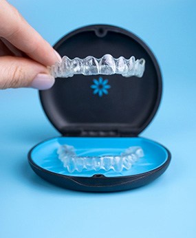 Patient placing Invisalign aligner in black and blue case